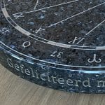 Tekst op de rand van een granieten zonnewijzer