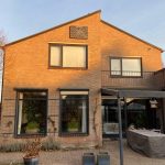 Natuursteen zonnewijzer op de muur van een huis, ontworpen en gemaakt door Hendrik Hollander