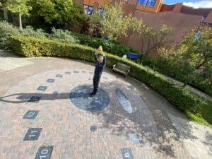 De schaduw van een persoon geeft de zomertijd aan op dit zonnewijzerplein