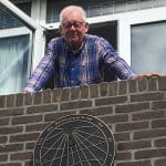 Zonnewijzer van brons, ontworpen voor de muur en met trotse eigenaar